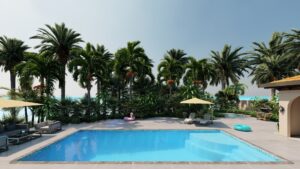 A rectangular outdoor swimming pool with a person on a pink float, surrounded by palm trees, lounge chairs, umbrellas, and tropical plants under a clear sky.